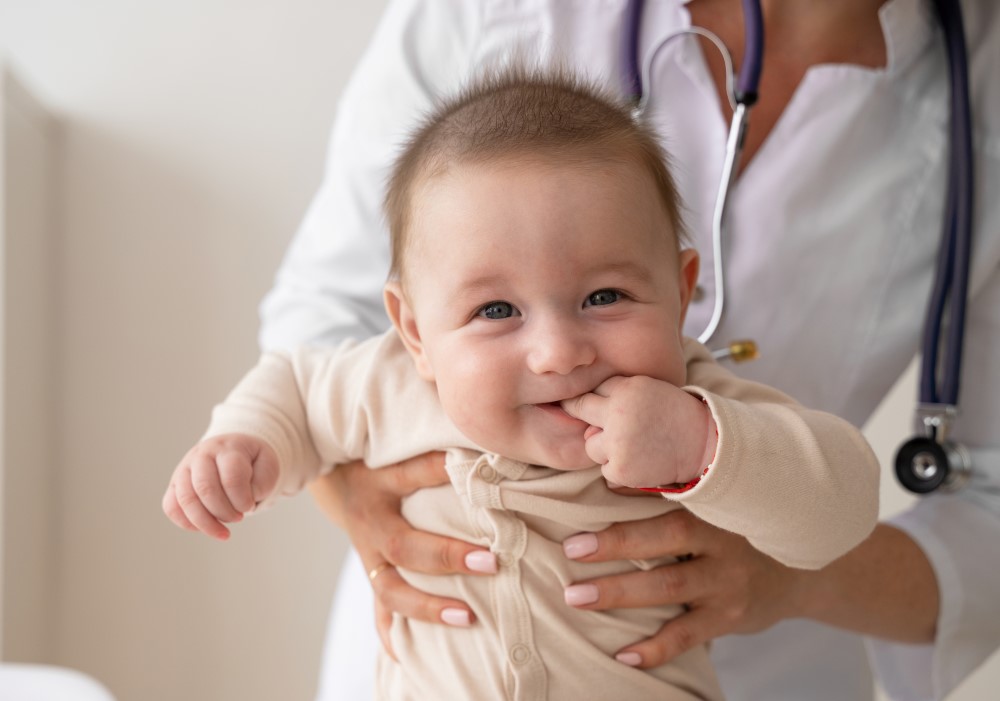 Un neonato sorridente tra le braccia della pediatra di Monteverde